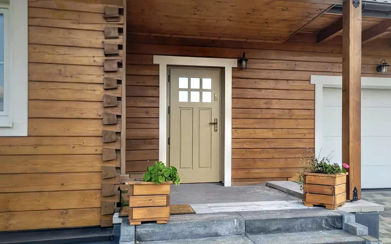 Ekskluzywne drzwi zewnętrzne wzór 507,10 w kolorze zółtym zamontowane w domu drewnianym